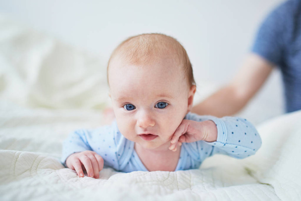 Baby girl learning to crawl. Little child doing tummy time. Infant kid in sunny nursery - 写真・画像