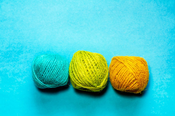 Set of yellowish green, orange and blue hemp threads isolated on blue color background. Colorful Tones, Flat lay. copy space for your text - Foto, Imagen