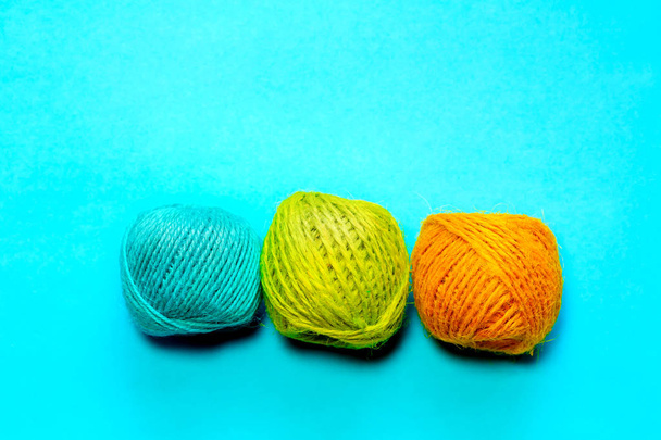 Set of yellowish green, orange and blue hemp threads isolated on blue color background. Colorful Tones, Flat lay. copy space for your text - Photo, Image