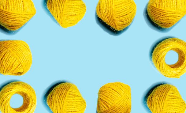 Set of yellow hemp threads isolated on blue color background. Colorful Tones, Flat lay. copy space for your text - Photo, image