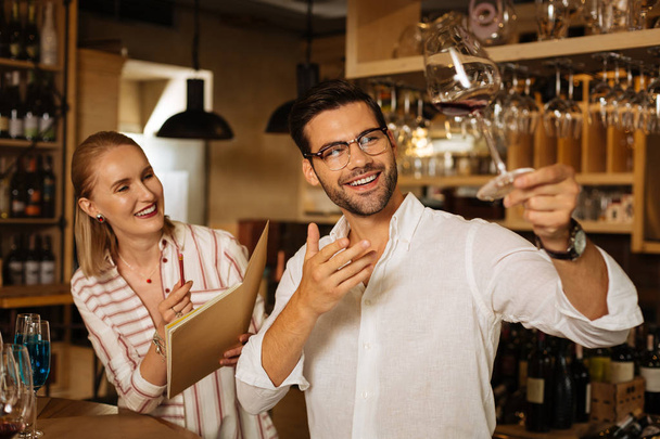 Happy positive man showing a glass of wine - Foto, Imagem