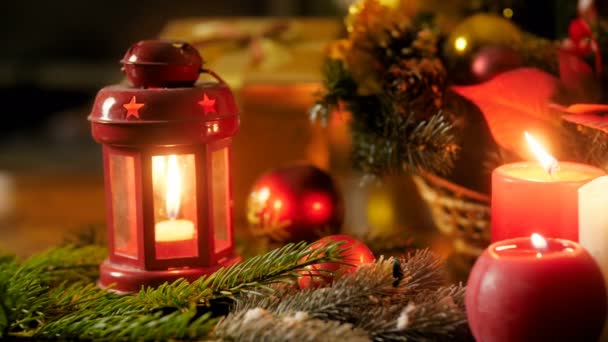 Panning 4k βίντεο από την καύση κεριά, φανάρια και Χριστούγεννα στεφάνι ξαπλωμένο στο τραπέζι. Τέλειο φόντο για χειμερινές εορτές και αργίες - Πλάνα, βίντεο
