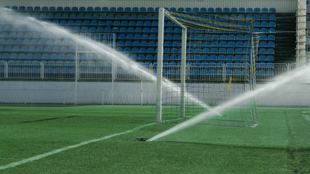 サッカーのフィールドで芝生のスプリンクラー。サッカー アリーナ水灌漑。草に水をまく - 映像、動画