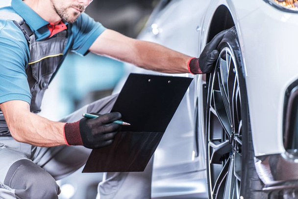 Auto Service Industry. Caucasian Car Technician with Vehicle Documentation in Hands. Automotive Theme. - Фото, изображение