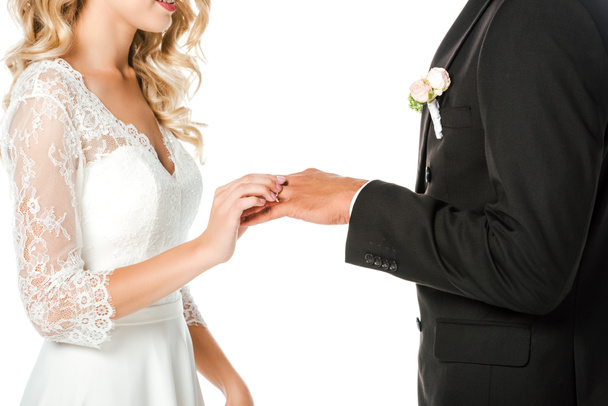 cropped shot of young bride putting on wedding ring on grooms finger isolated on white - Φωτογραφία, εικόνα