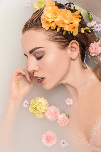 Mujer sexy joven relajándose en el baño con flores
 - Foto, Imagen