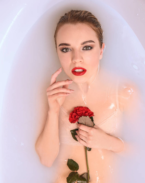 Jeune femme sexy se détendre dans le bain avec des fleurs, vue sur le dessus
 - Photo, image