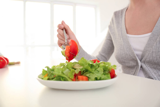 Молодая женщина ест свежий салат дома. Концепция здорового питания
 - Фото, изображение