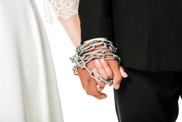 cropped shot of bride and groom holding hands tied in chain isolated on white - Fotografie, Obrázek