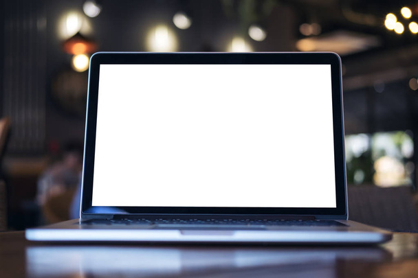 Makett laptop-val a sötét modern kávéház fából készült asztal üres fehér képernyő képe - Fotó, kép