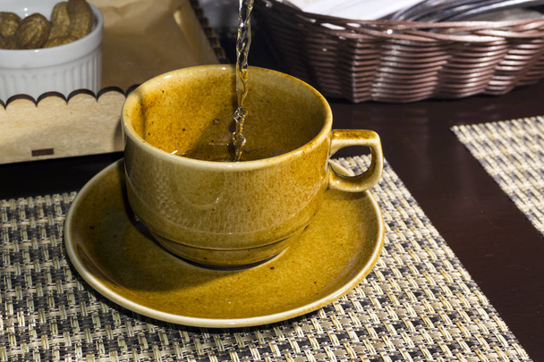 taza de esmalte manchado amarillo con té verde primer plano sobre fondo borroso
 - Foto, Imagen