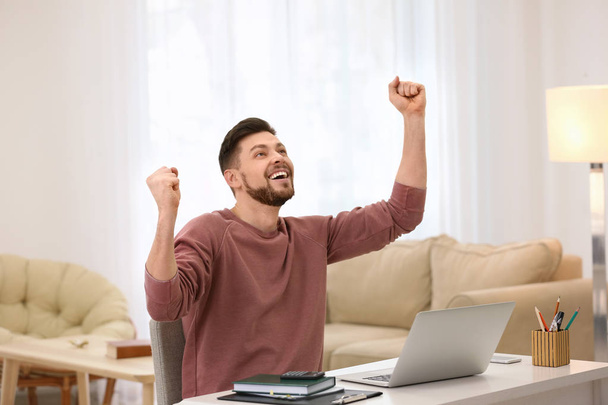 Happy excited freelancer with laptop at home - Photo, image