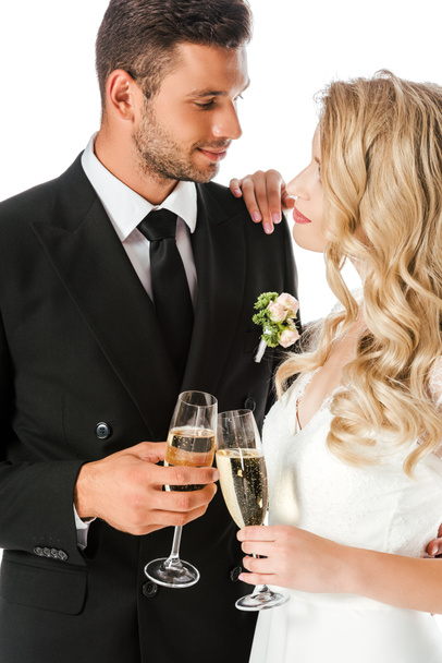beautiful young bride and groom clinking glasses of champagne isolated on white - Photo, Image