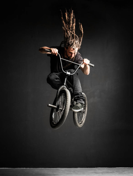 Man doing extreme stunt on BMX bicycle. Professional rider. Sport. - Photo, Image