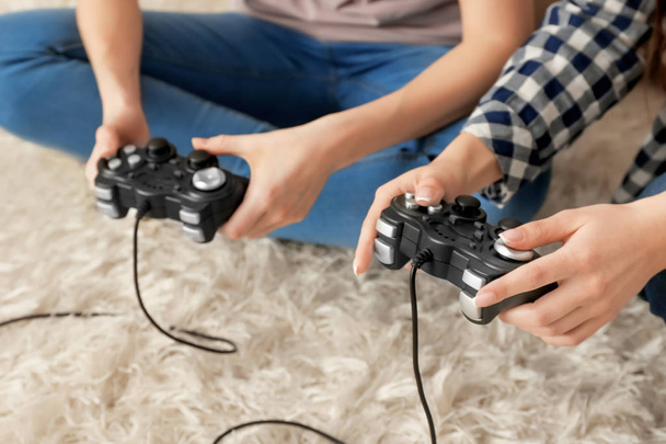 Jovens mulheres jogando videogames em casa, close-up
 - Foto, Imagem