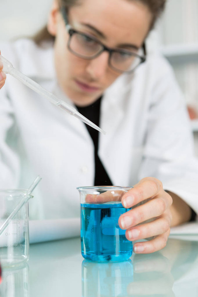 female trainee working with chemical liquids in lab - Фото, зображення