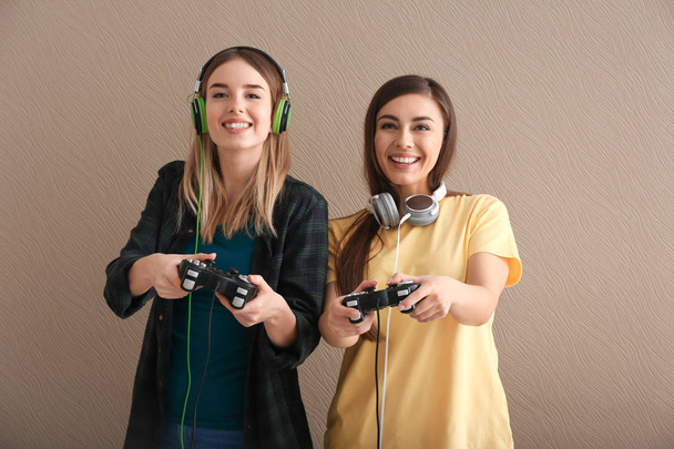 Молоді жінки з геймпадами на кольоровому фоні
 - Фото, зображення