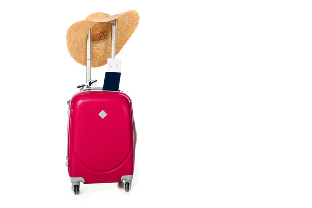 close up view of pink suitcase, straw hat, passport and ticket isolated on white - Photo, Image