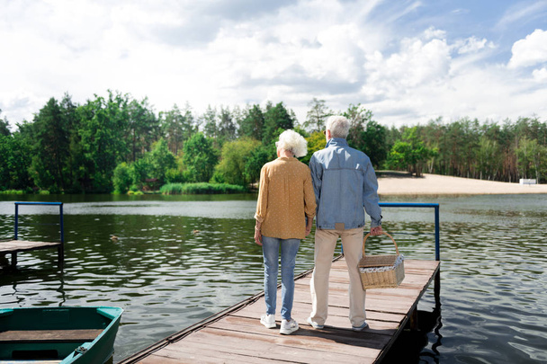 Stylish elderly wife and husband having romantic date near river - Fotografie, Obrázek