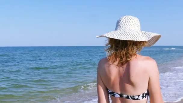 4K. Mujer en traje de baño, caminando en la playa del mar. Disparo constante, vista trasera
 - Metraje, vídeo