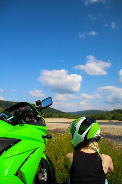 Sarışın kız ile Dağları arka plan üzerinde yeşil spor motosiklet. Doğa üzerinde motosiklet. Ukrayna. - Fotoğraf, Görsel