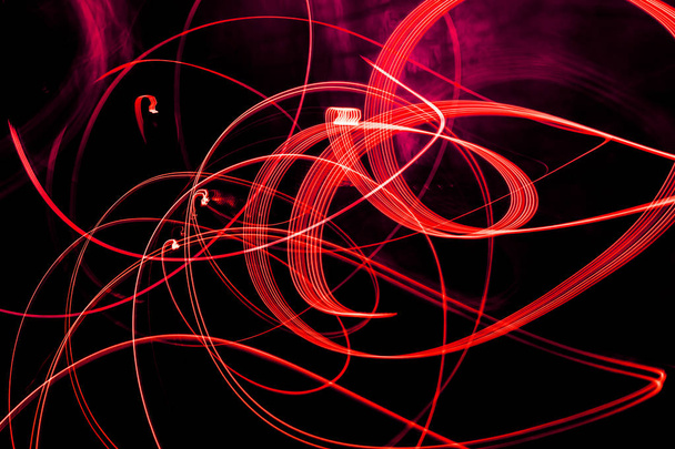 Bright red spiral patterns from light strips on a black background - Photo, Image