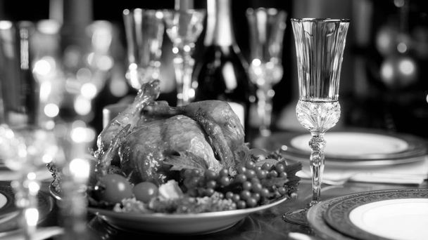 Черно-белое изображение запеченного цыпленка на праздничном обеденном столе
 - Фото, изображение