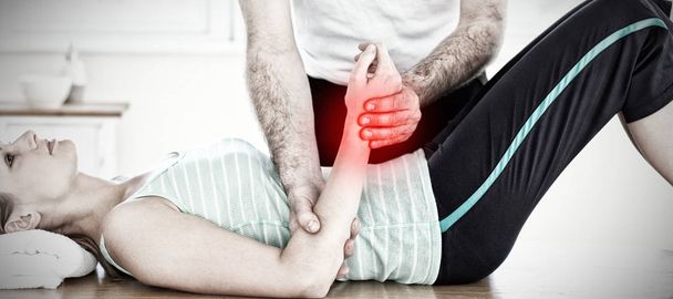Highlighted pain against physical therapist holding woman hand - Φωτογραφία, εικόνα