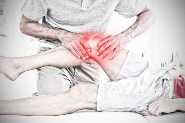 Highlighted pain against male physical therapist massaging patient knee - Fotografie, Obrázek