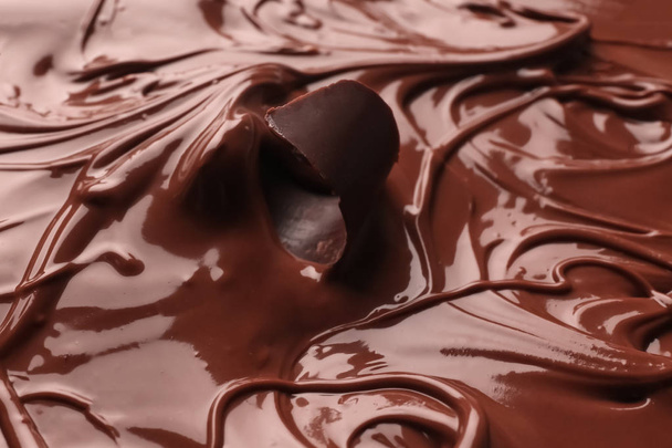 Piece of curl in tasty melted chocolate, closeup - Φωτογραφία, εικόνα