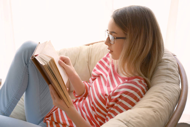 Молода жінка читає цікаву книгу вдома
 - Фото, зображення