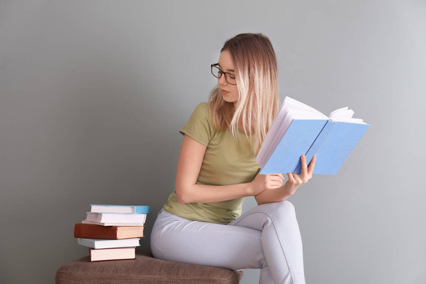 Jeune femme lecture livre près du mur de couleur
 - Photo, image
