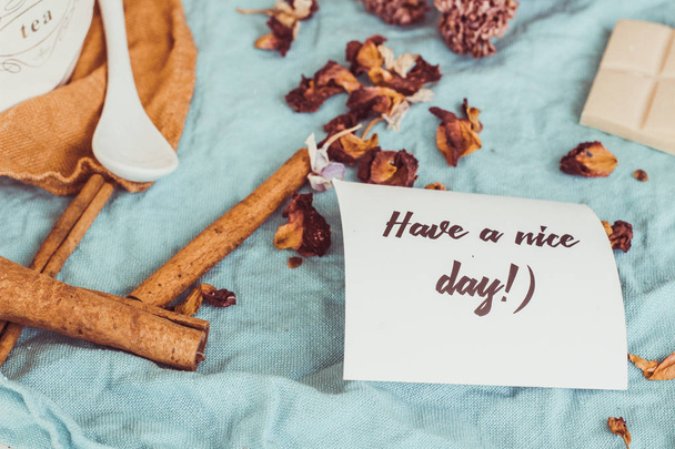 Chocolate, rosa, café y canela. Diseño sobre un fondo azul. Placa "Que tengas un buen día
". - Foto, Imagen