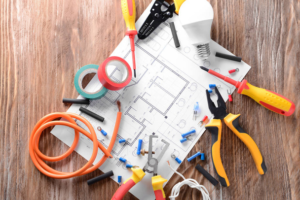 Electrician's supplies with house plan on wooden background - Photo, Image