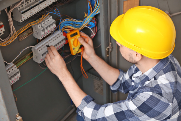 Electrician measuring voltage in distribution board - Photo, Image