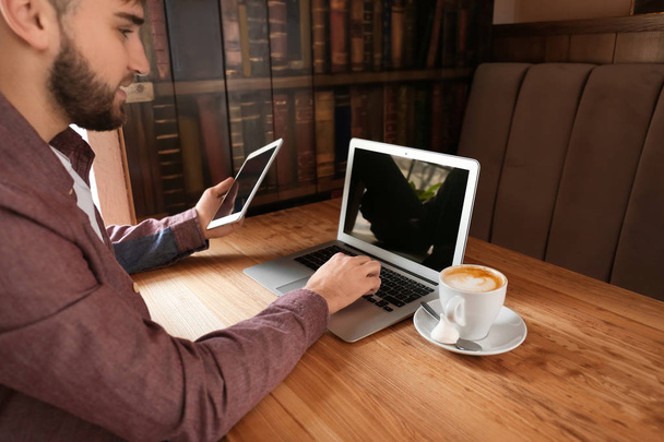 Νέοι freelancer με tablet Pc και το φορητό υπολογιστή που εργάζονται στο καφενείο - Φωτογραφία, εικόνα