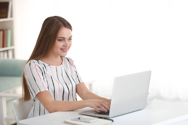 Θηλυκό ελεύθερος επαγγελματίας εργάζεται σε φορητό υπολογιστή στο γραφείο στο σπίτι - Φωτογραφία, εικόνα