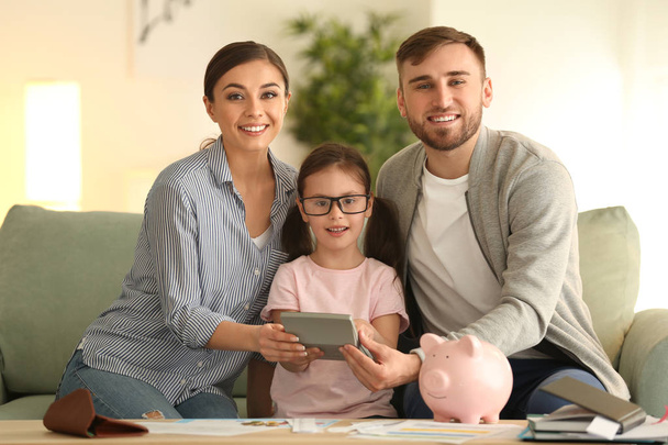 Gelukkige familie tellen van geld binnen. Geld besparing concept - Foto, afbeelding