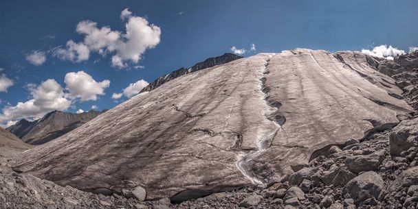 Amazing panorama of a beautiful glacier with cracks and ice breaks, taken from the foot of the glacier, against a blue sky with clouds - Fotoğraf, Görsel