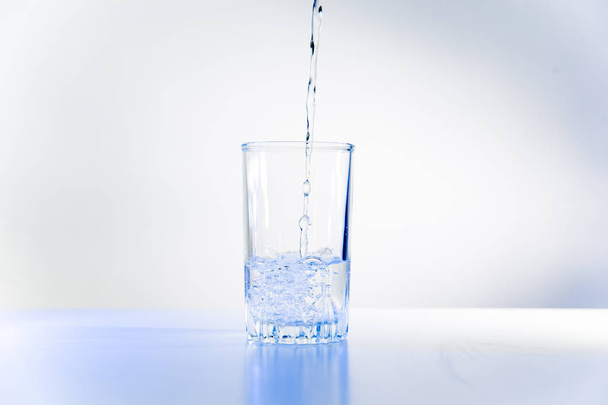 Glass of pure water on a white kitchen table - Foto, Imagem