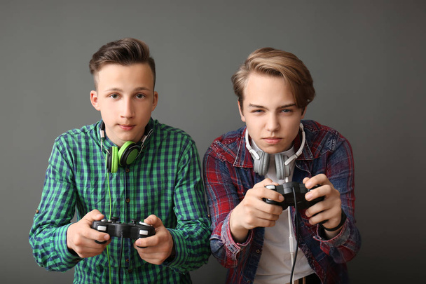 Подростки с геймпадами на сером фоне
 - Фото, изображение