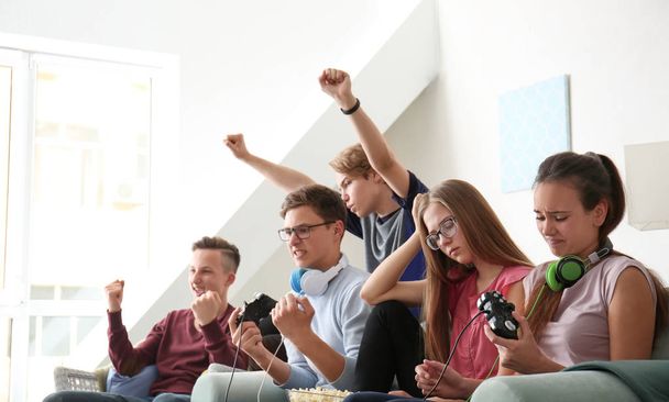 Teenagers playing video games at home - Fotó, kép