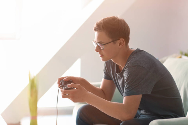 Adolescent jouer à des jeux vidéo à la maison - Photo, image