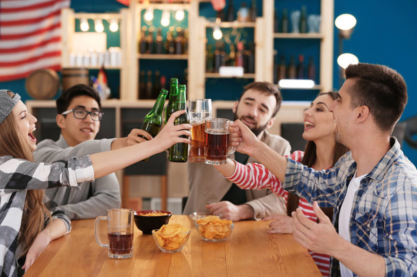 Gruppe fröhlicher Freunde trinkt Bier in Bar - Foto, Bild