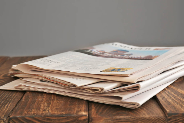 Pile of newspapers on wooden table - Foto, afbeelding