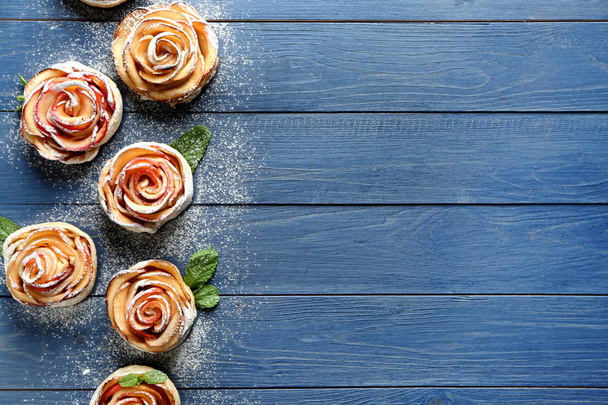 Smakelijke rose vormige appel gebak op houten tafel - Foto, afbeelding