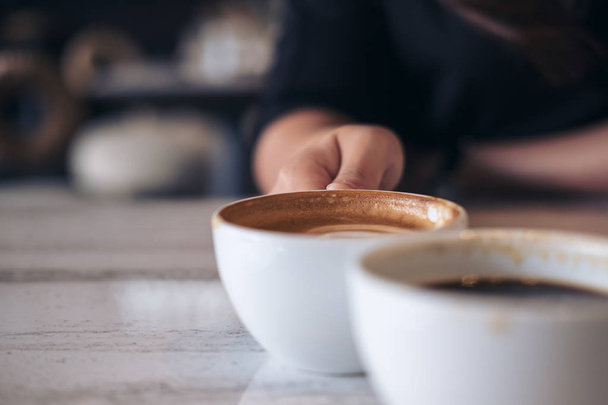 Close up immagine di due persone battere tazze di caffè bianco su tavolo di legno in caffè
 - Foto, immagini