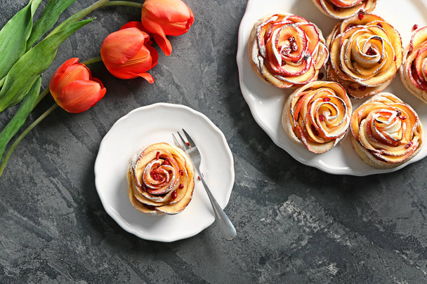 Platos con sabroso pastel de manzana en forma de rosa en la mesa
 - Foto, Imagen