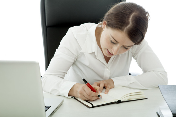 young brunette business woman writing text in book - Foto, Bild
