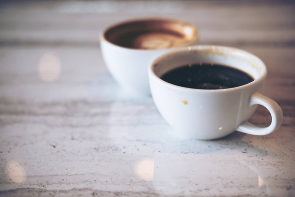 Közelkép kép két fehér csésze forró latte kávé és kávé márvány tábla modern kávézó Americano - Fotó, kép